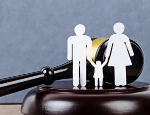 Découpes de papier représentant une famille avec un marteau en arrière-plan